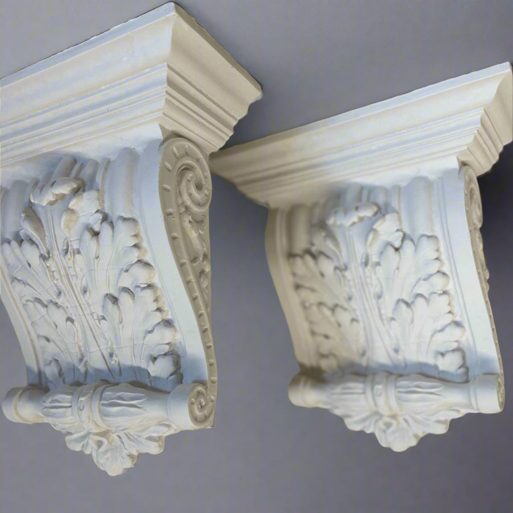 Decorative white corbels with intricate carvings on a gray background